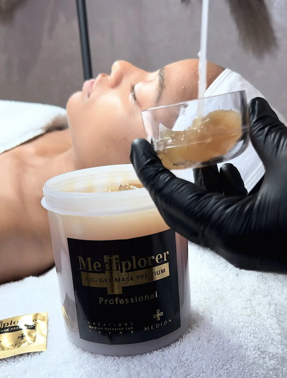 美容師調和 Mediplorer CO₂ Gel Mask Professional 凝膠面膜，示範美容院外敷面膜的備料與塗敷情境