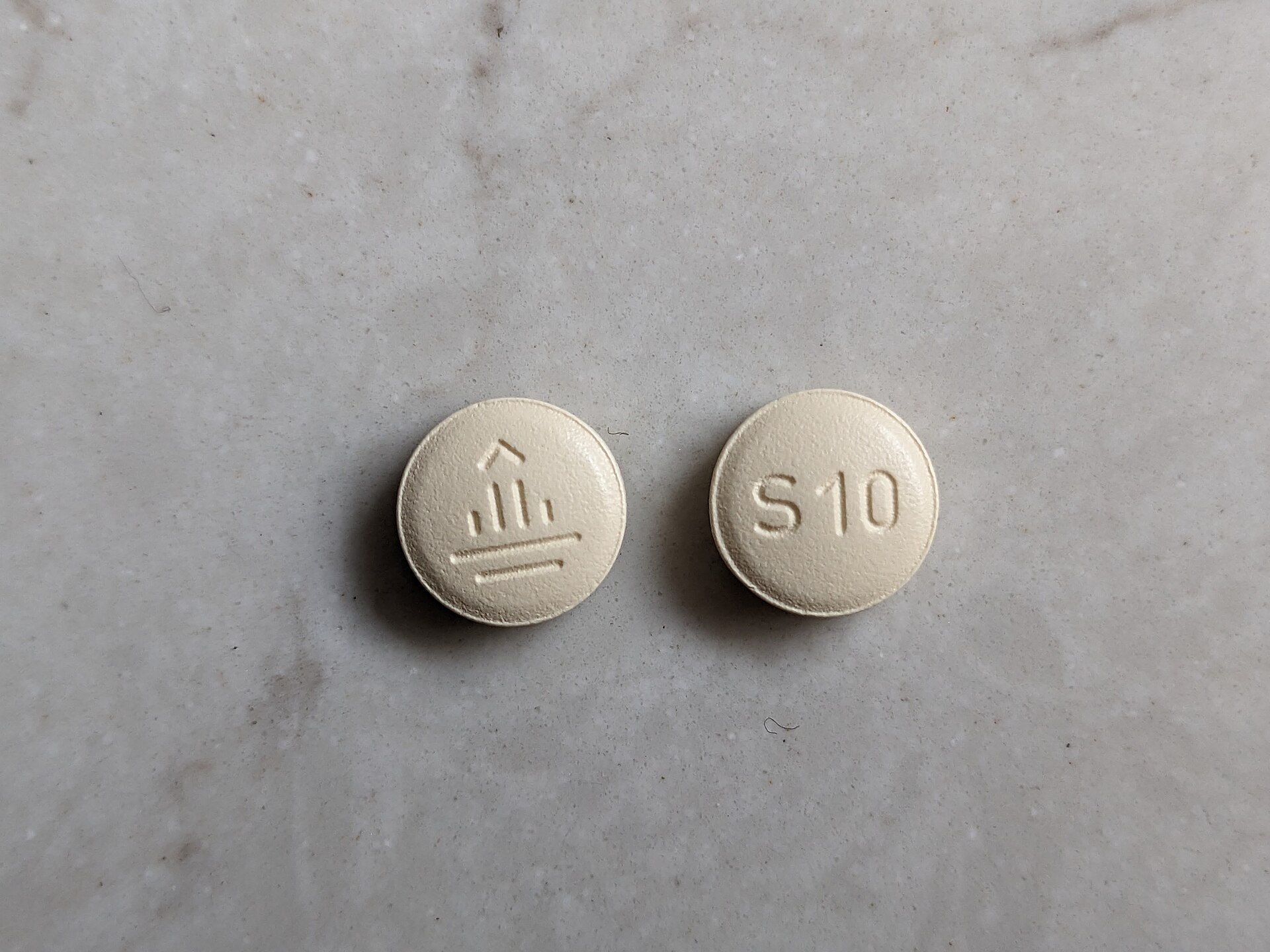 美國標示 Jardiance 10 mg 實際錠劑,兩面分別可見 BI 標誌與 S10 刻印