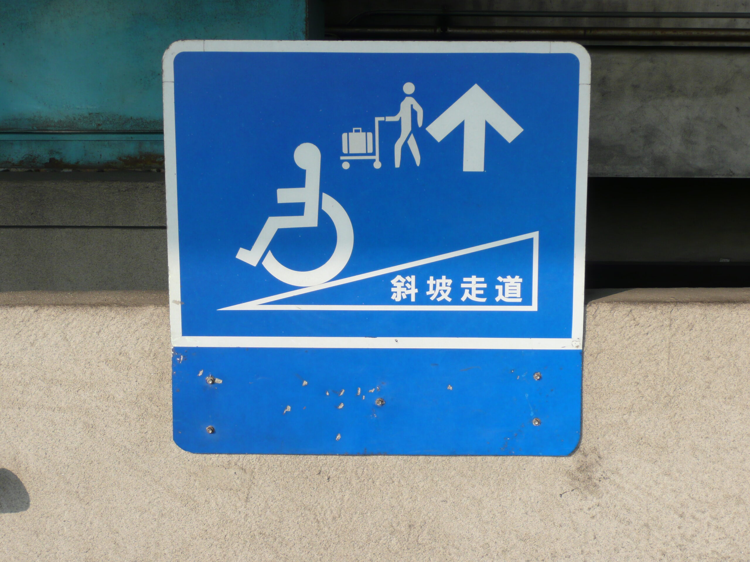 台灣標示輪椅與行李推車可通行斜坡的藍色指示牌