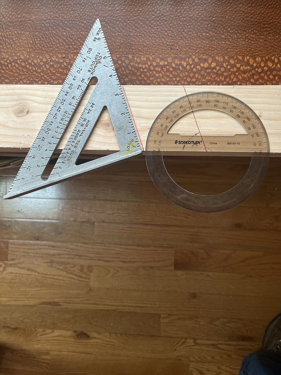 透明量角器與角尺同時對照木板上的角度,量角器刻度可見以度為單位的讀值