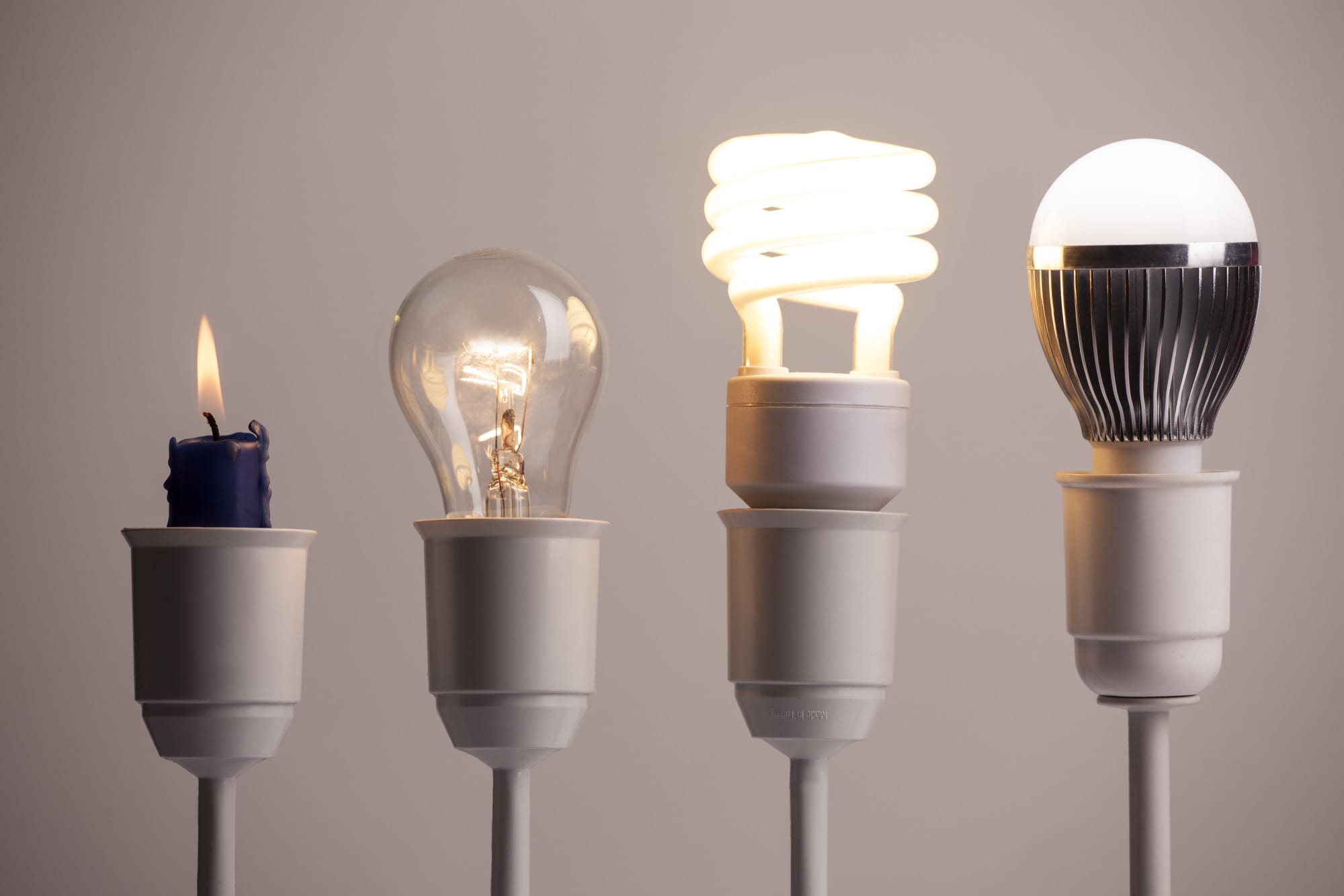 蠟燭、白熾燈泡、緊湊型螢光燈與 LED 燈泡並列實物