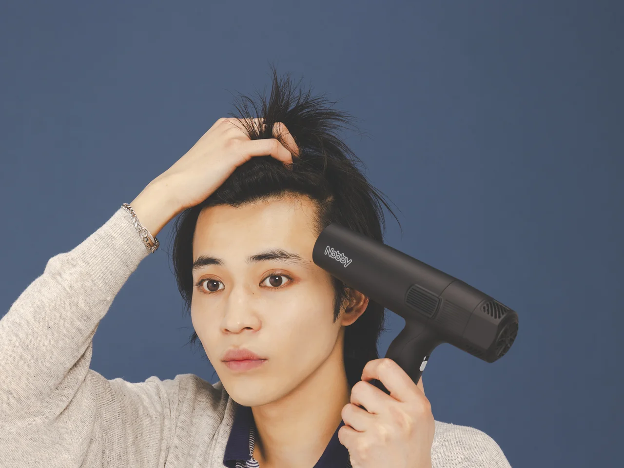 男士以吹風機吹起前額髮根的操作示範