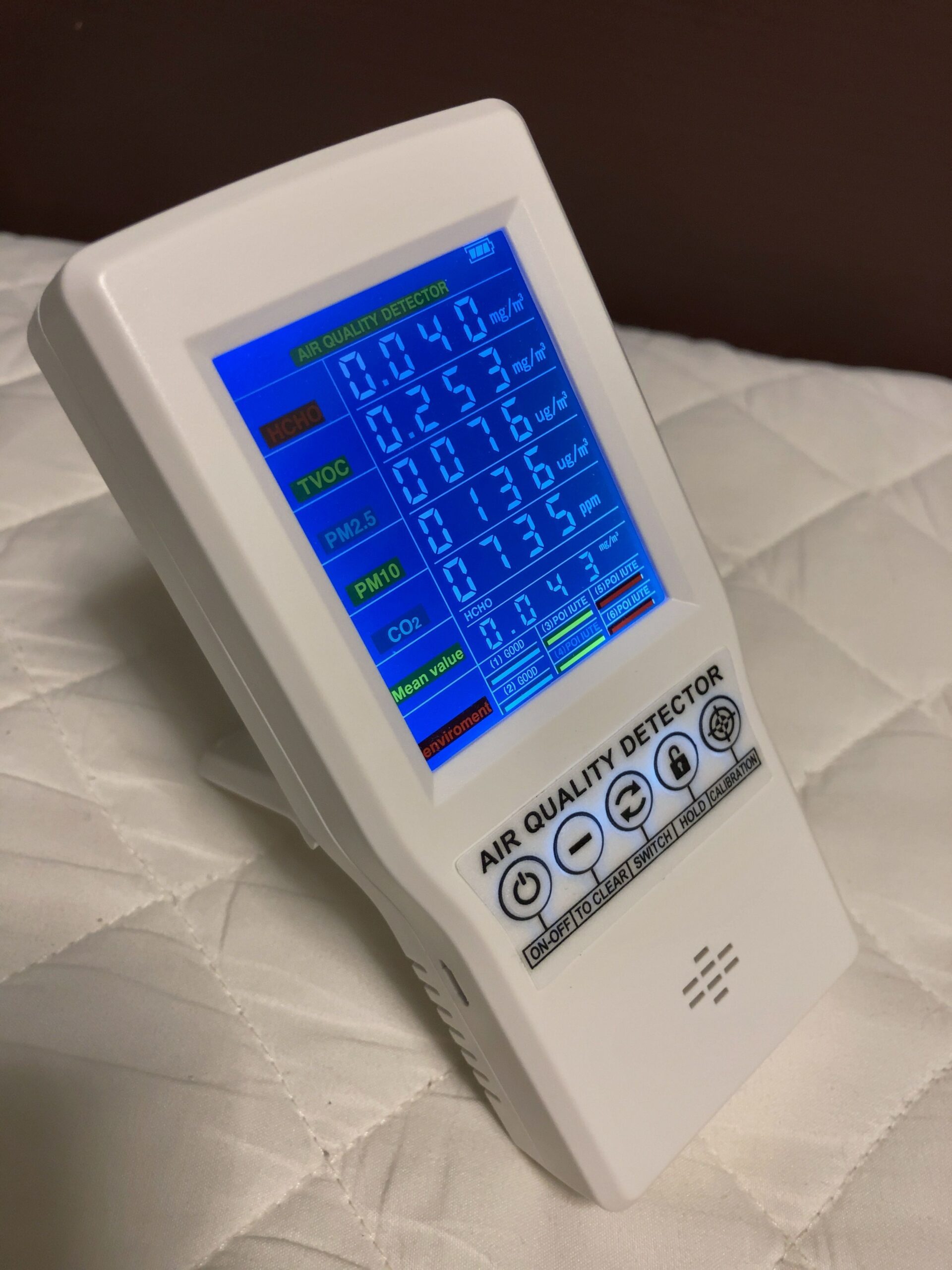 手持空氣品質監測器螢幕列出 PM2.5、PM10 與其他污染物濃度欄位
