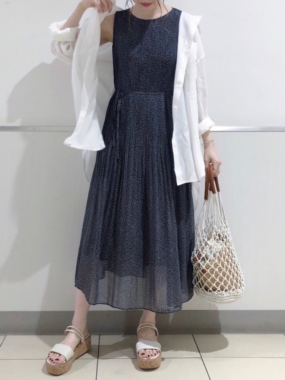 日本女性以白襯衫、深藍底細花洋裝、籐編包和平底涼鞋組成日常穿搭