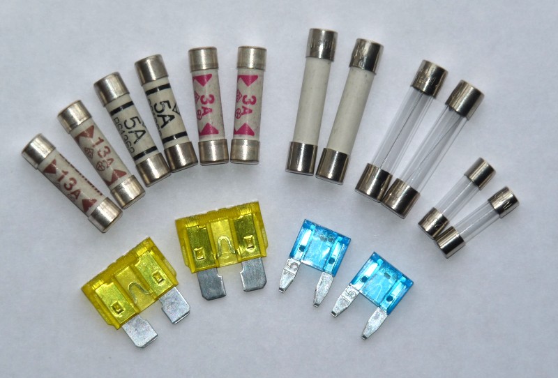 不同外形的管型熔斷器與車用插片熔斷器並排，呈現保險絲外型與尺寸系列的差異