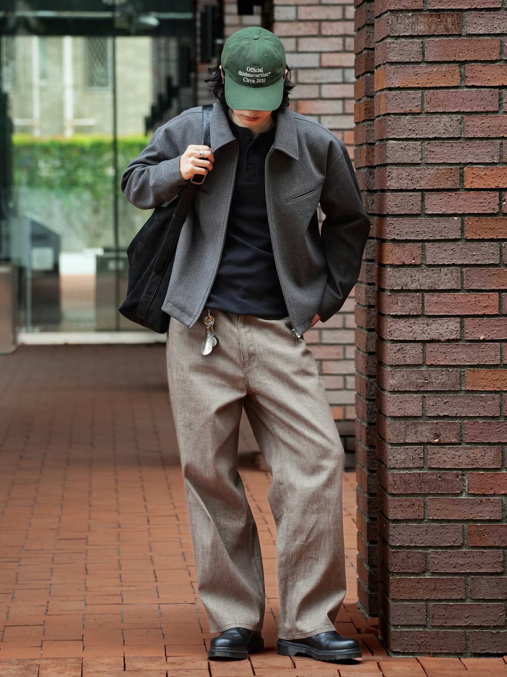 日本男性穿灰色短版翻領外套與黑色長袖亨利領上衣，搭配淺褐色寬直筒丹寧褲和黑色切爾西靴