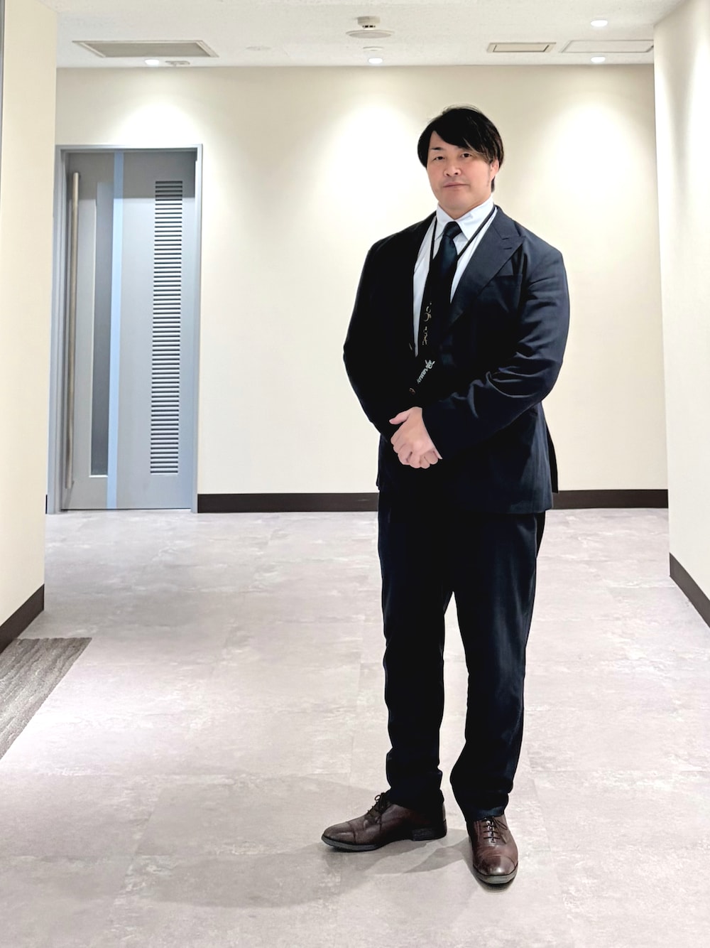 深色成套西裝配白襯衫與領帶，呈現從肩線、衣襬到鞋款的正式全身比例。
