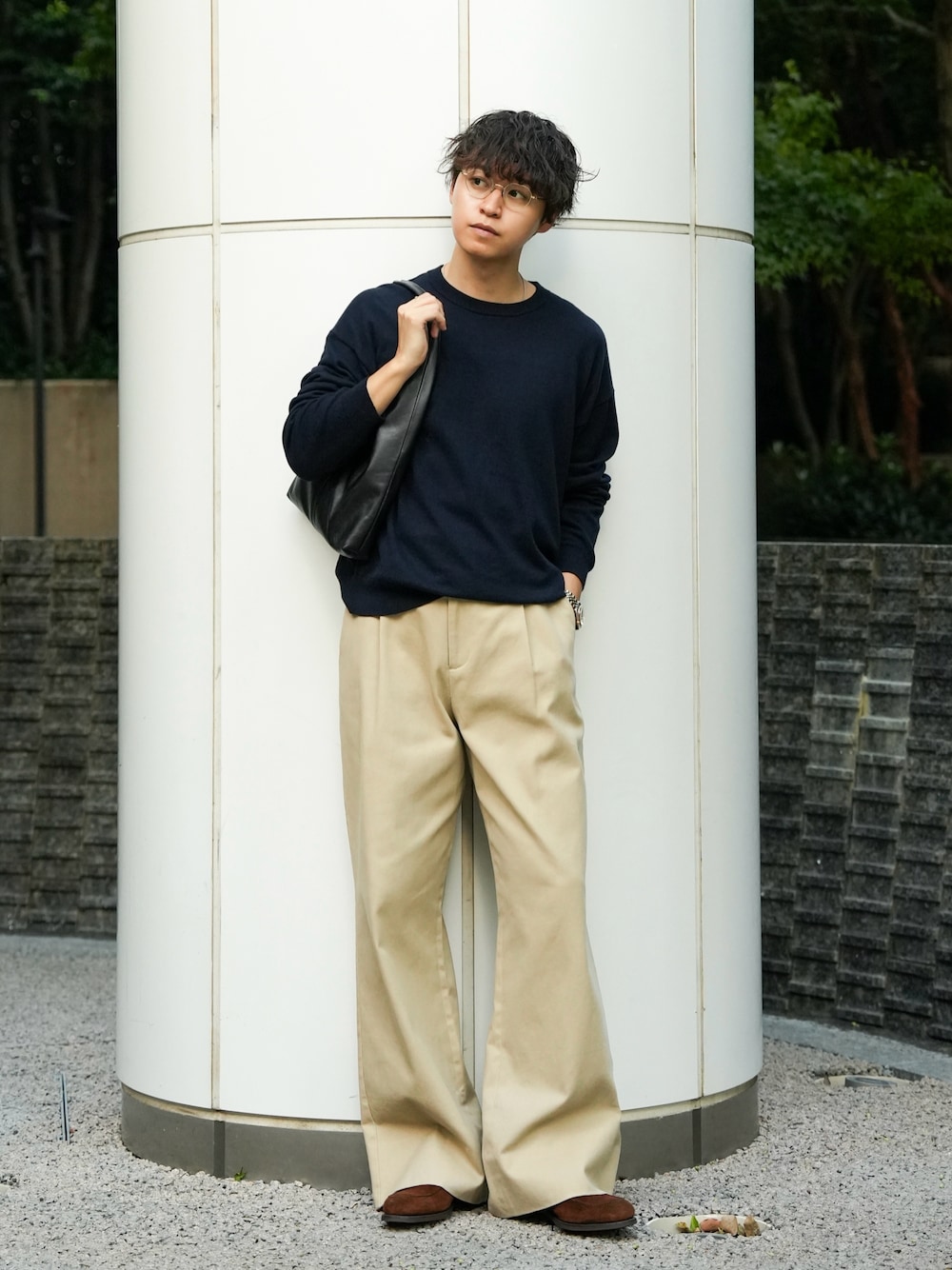 深色針織上衣配卡其寬直筒褲與棕色鞋,示範日常城市穿搭以簡潔色塊和適度鬆量建立輪廓。