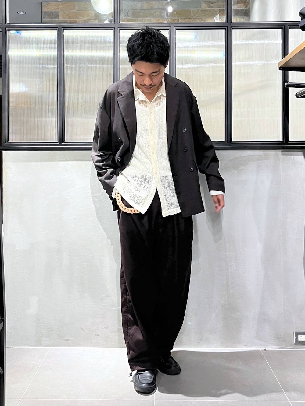 180 公分男性以棕色外套、淺色襯衫和深色長褲示範全身比例；袖長與褲長仍應實量，不能只按身高推估。