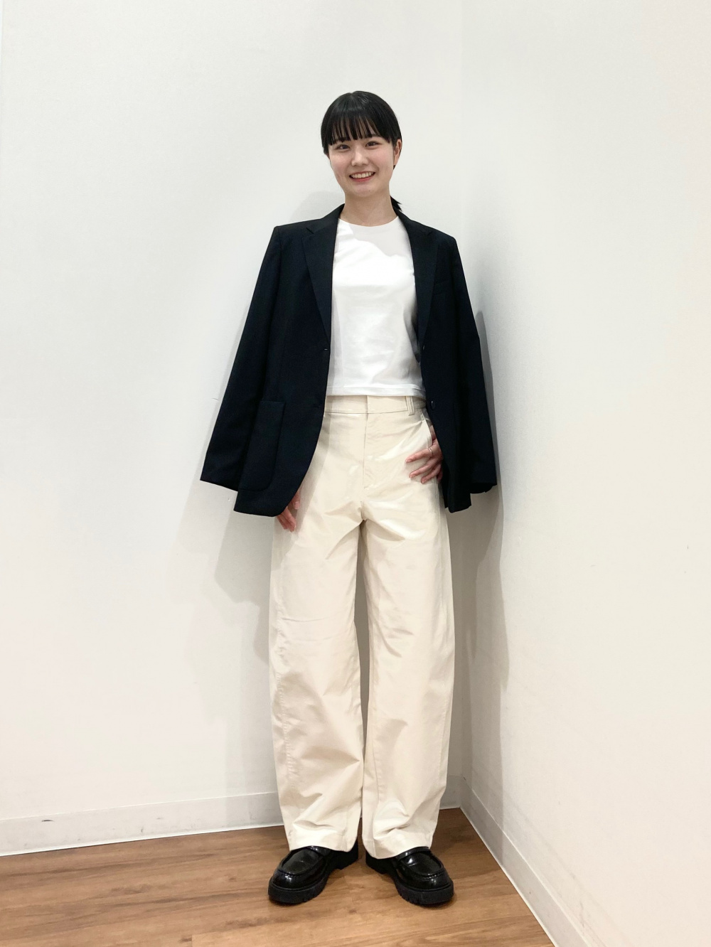 日本女性穿白T、黑色西裝外套、奶油色寬褲和黑色樂福鞋