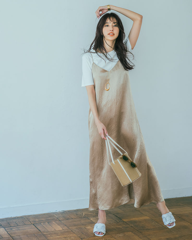 日本女性在白T外穿米色細肩帶緞面長洋裝,配項鍊、草編袋與白色平底鞋