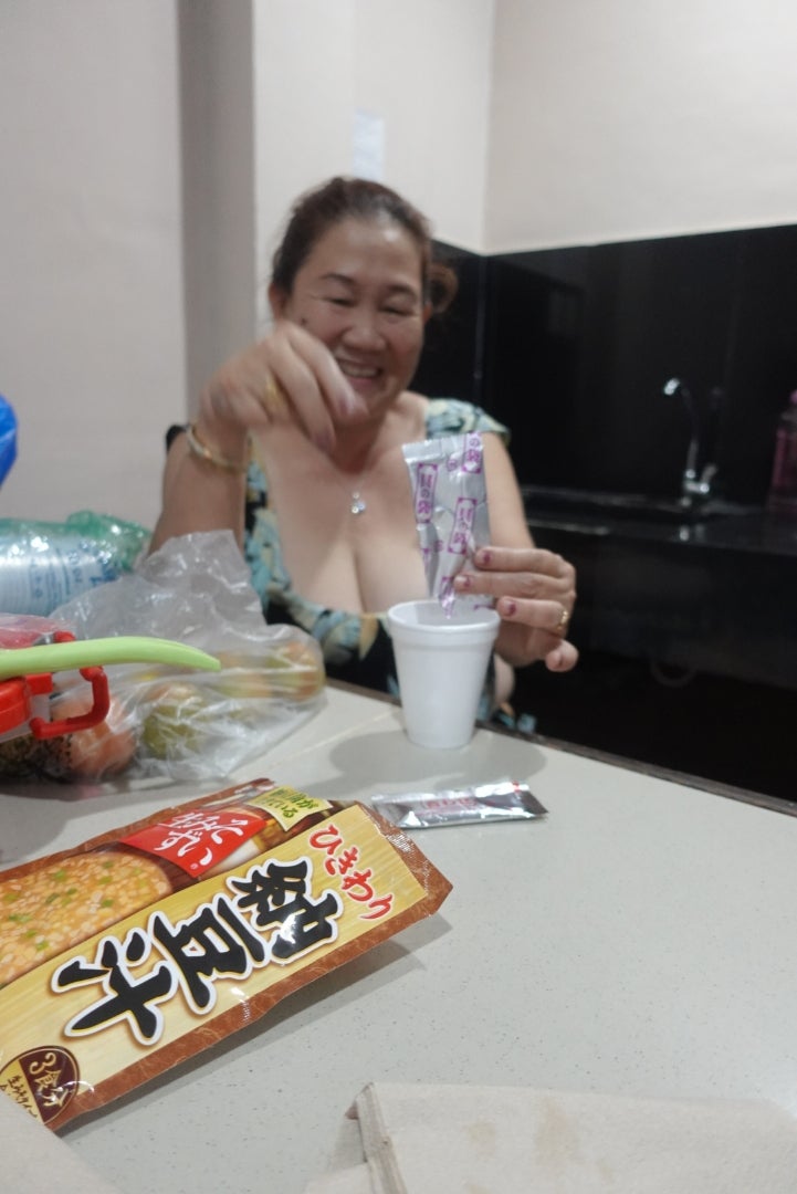 消費者拆開旭松納豆汁單食包並倒入杯中的實拍