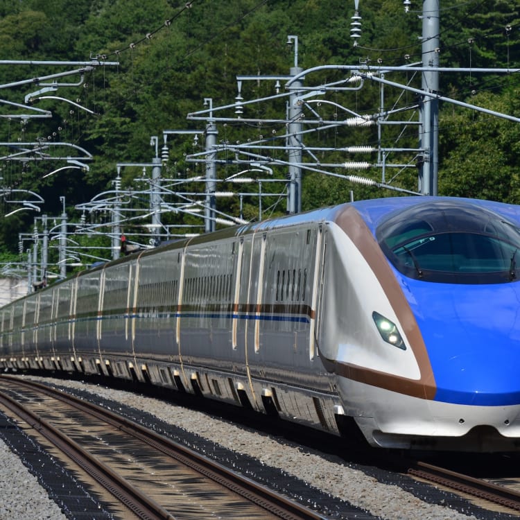日本新幹線列車行駛於山林旁的軌道