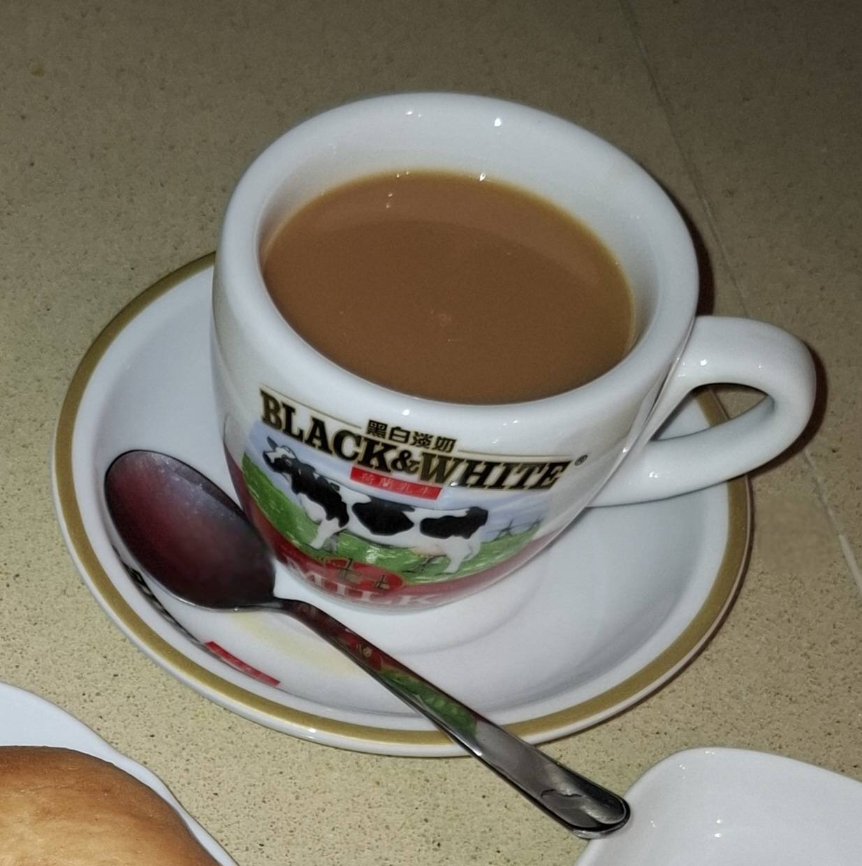 港式奶茶盛於黑白淡奶杯的照片
